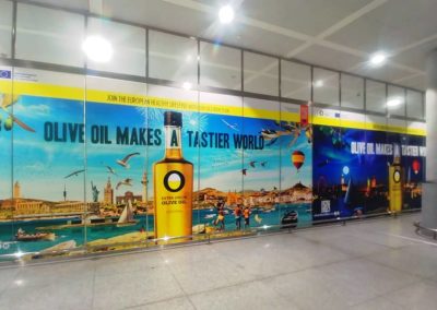 Impresión de vinilos y montaje para la campaña publicitaria de aceite de oliva en el Aeropuerto de Málaga.