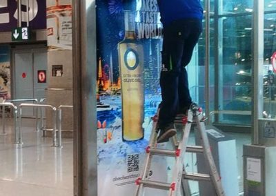 Impresión de vinilos y montaje para la campaña publicitaria de aceite de oliva en el Aeropuerto de Málaga.