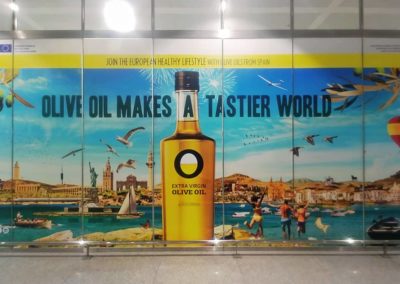 Impresión de vinilos y montaje para la campaña publicitaria de aceite de oliva en el Aeropuerto de Málaga.