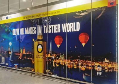 Impresión de vinilos y montaje para la campaña publicitaria de aceite de oliva en el Aeropuerto de Málaga.